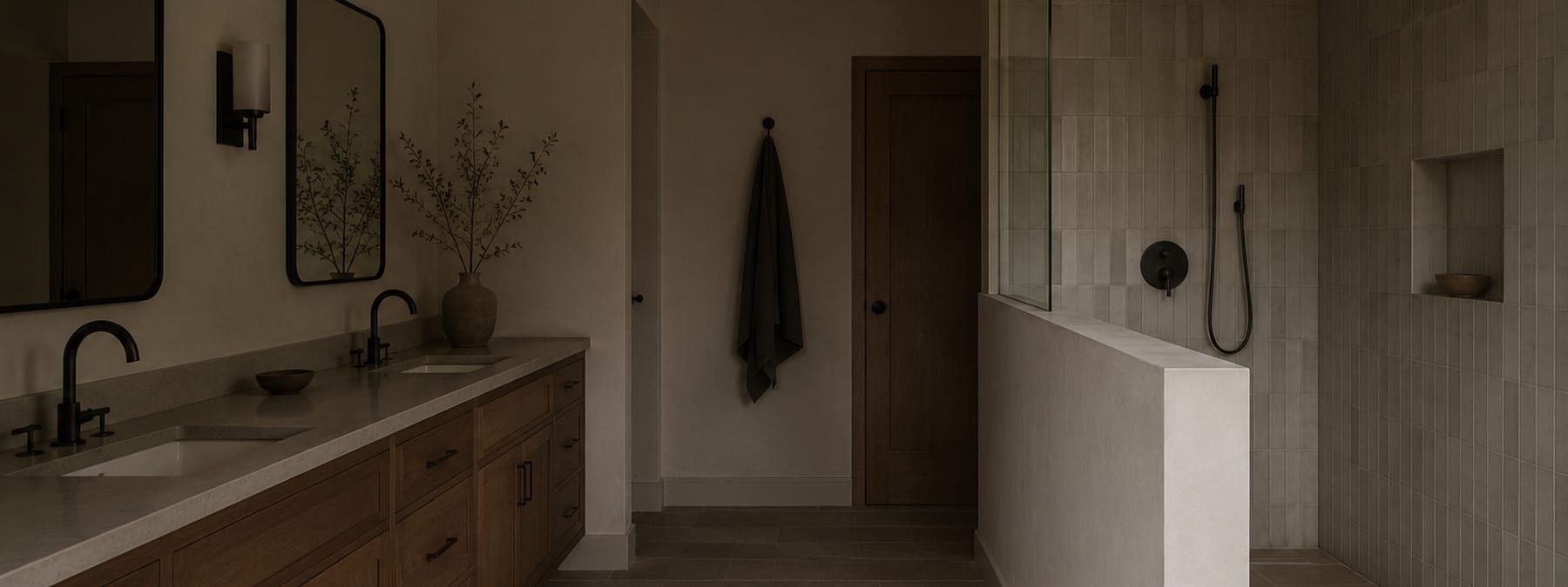 A finished bathroom photographed from the doorway with the vanity lit from above