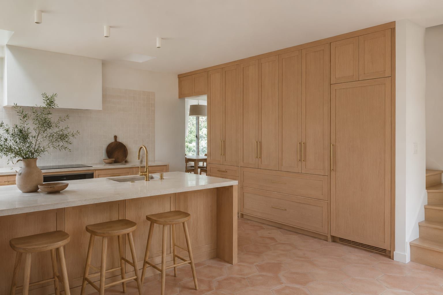 A pair of tall pantry cabinets flanking a refrigerator with matching doors