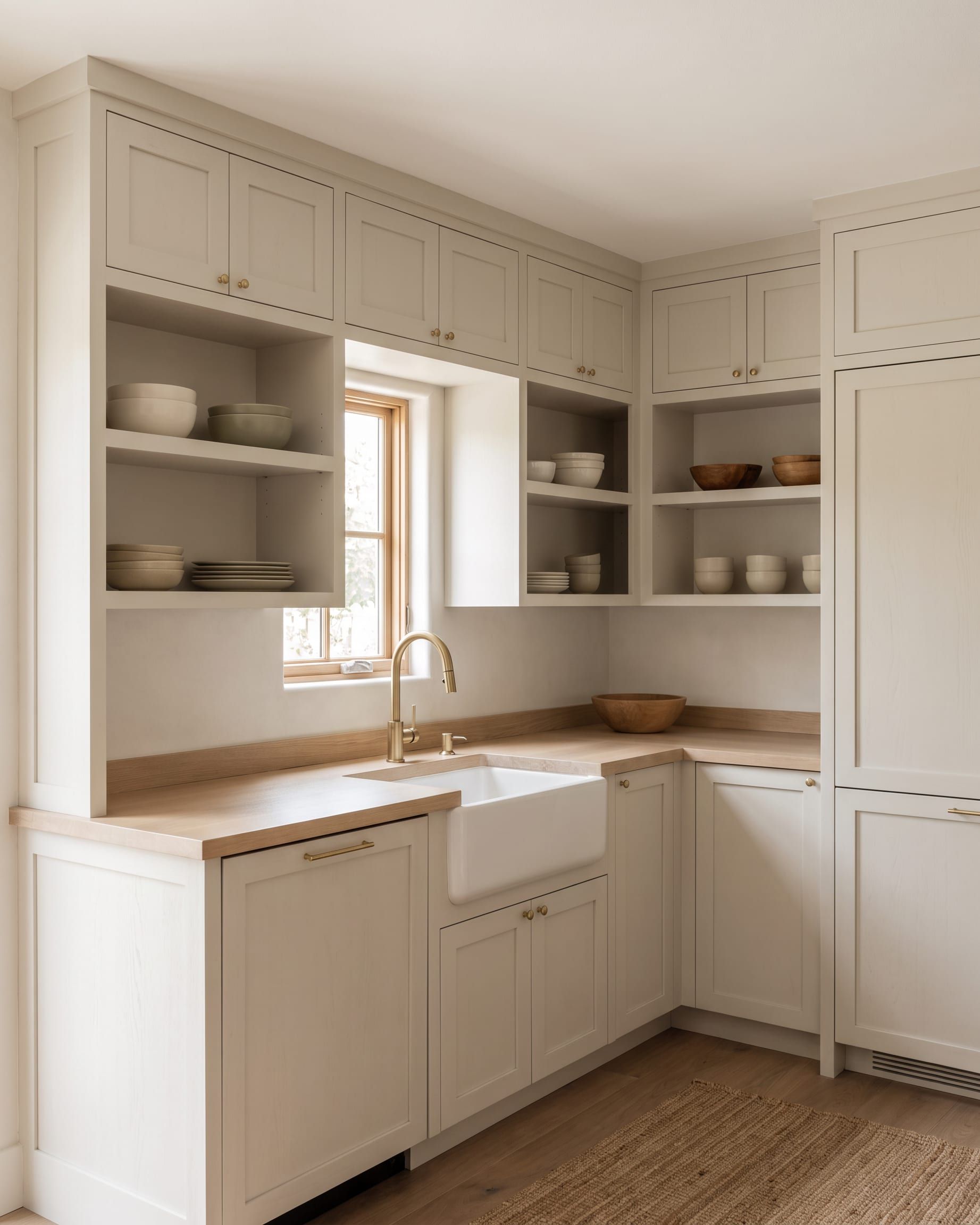 A compact bathroom with a shallow wall hung vanity and a tall narrow storage cabinet beside it