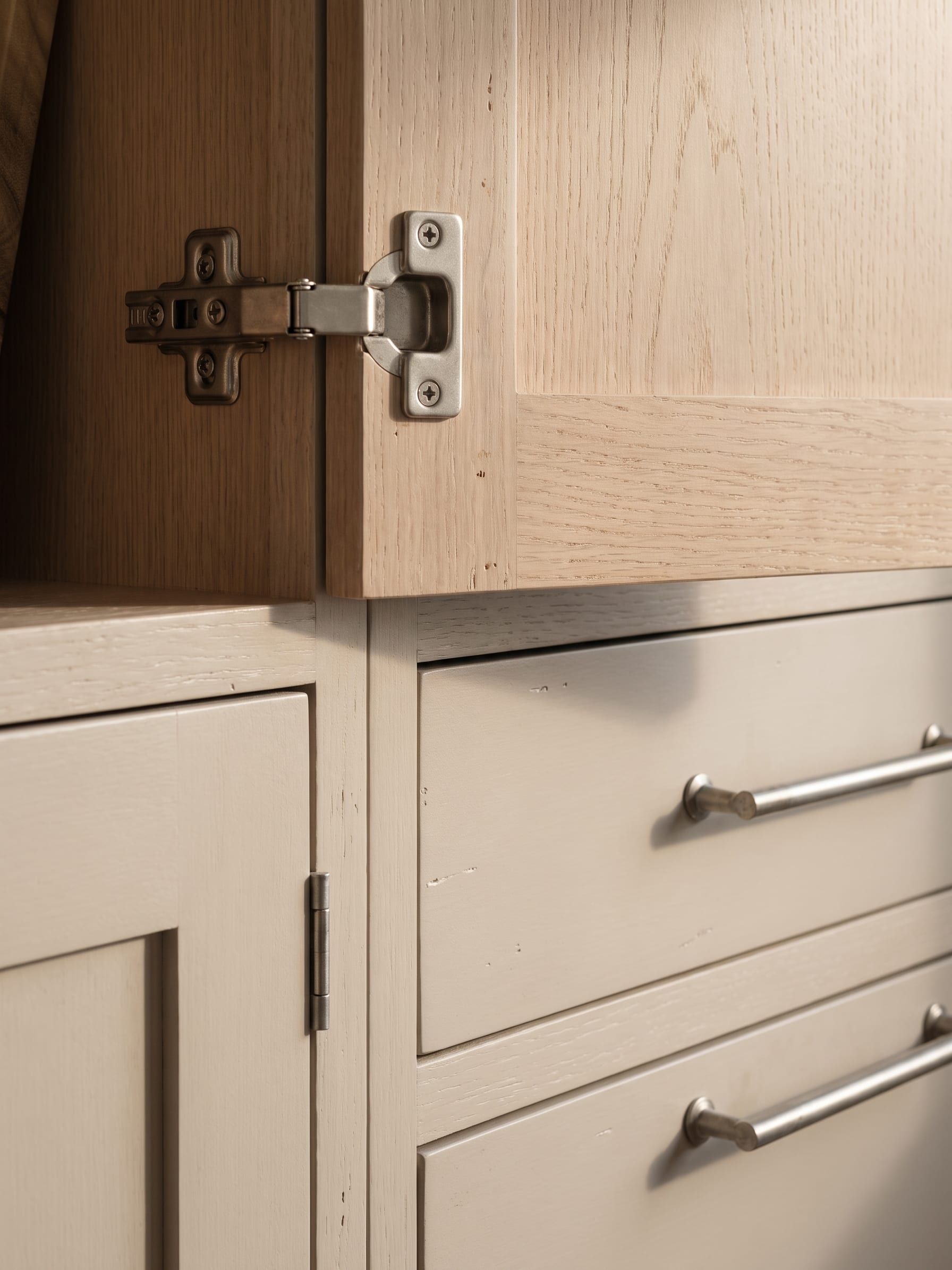 A stainless hinge and screw shown against a sealed panel edge