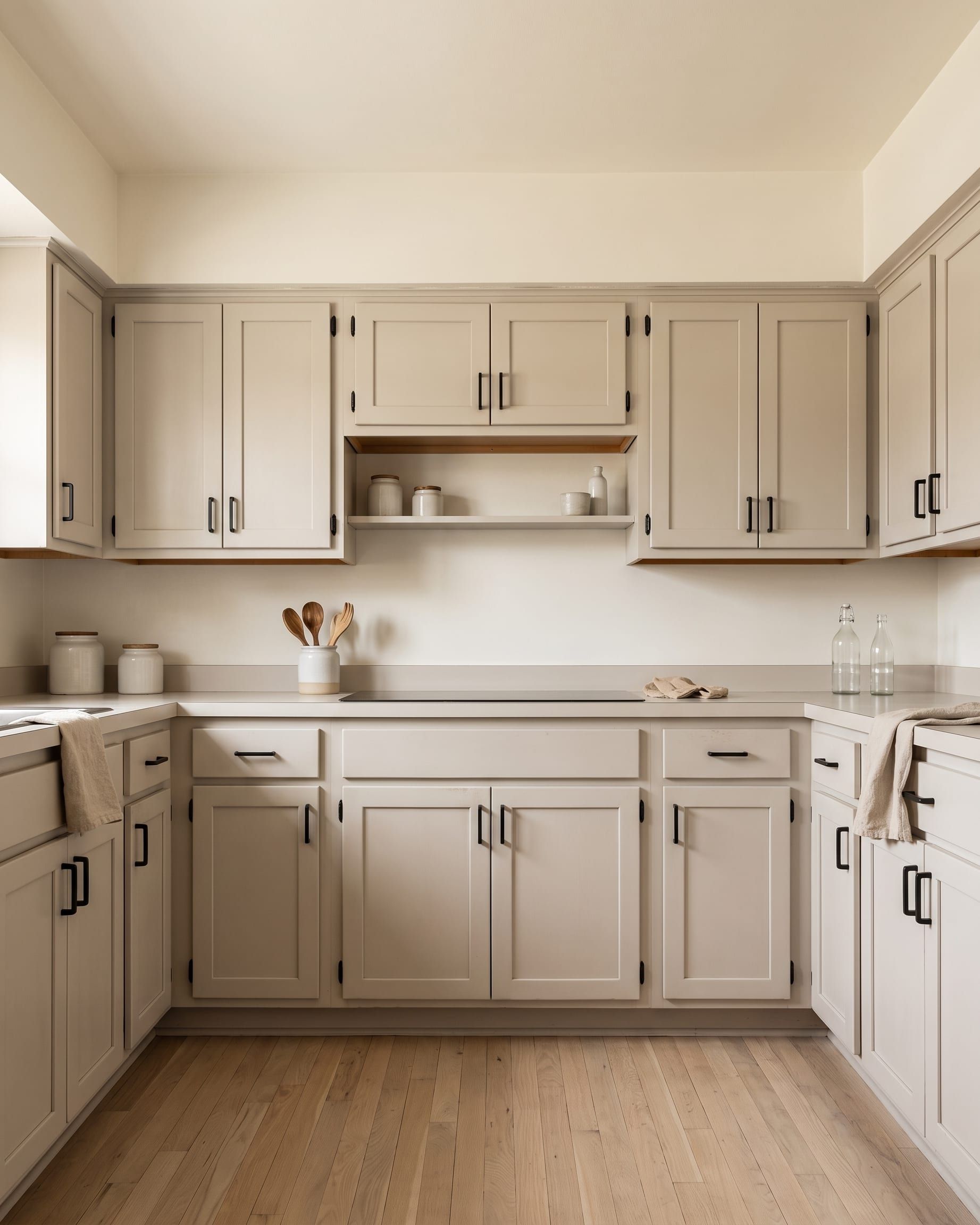 A compact kitchen with newly refaced doors in a warm white and updated handles